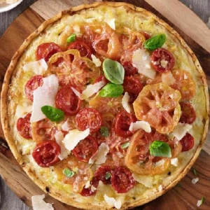 Pizza con mezcla de tomates frescos, albahaca y queso Grana Padano
